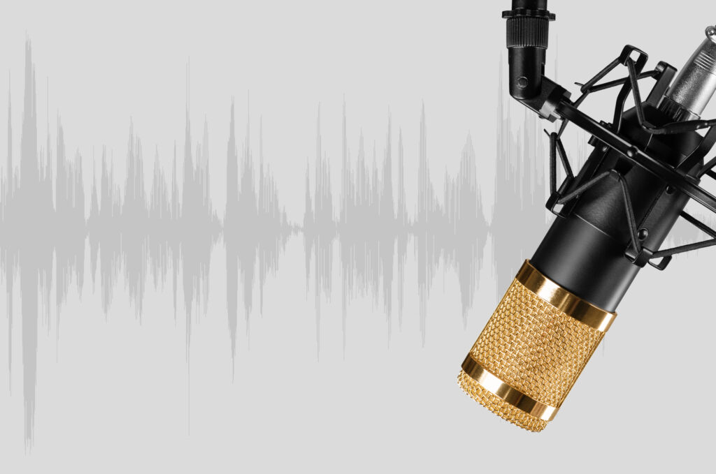 Microphone noir et doré devant une onde sonore grise