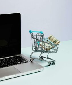 Mini caddy rempli de billets posés sur un ordinateur