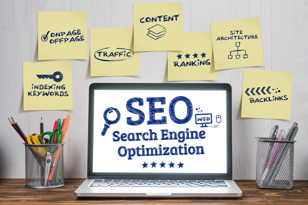 Ordinateur affichant « SEO » entouré de notes autocollantes
