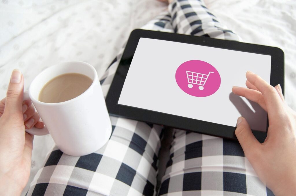 Personne avec tablette et café faisant du shopping en ligne
